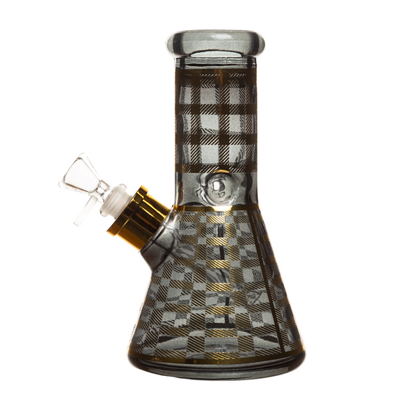 A clear glass bong with a checkered pattern, featuring a down stem bowl, a gold-colored knob on the side, and a gift box in the background.