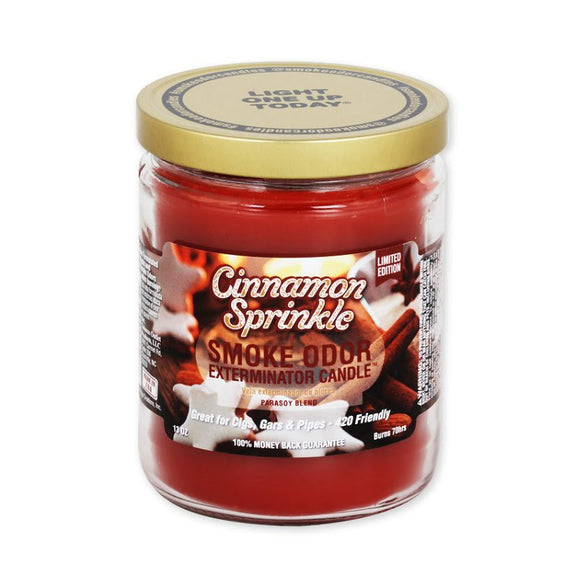 Jar of cinnamon sprinkle candle with a gold lid on a white background