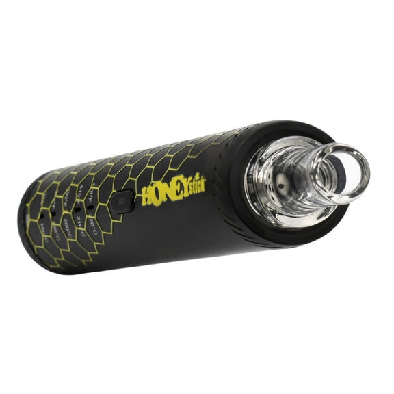 The image shows a dry herb vaporizer pen with a black body and a yellow and orange box with the HONEYstick brand on it. The vaporizer is designed for heating chamber with precision temperature settings.